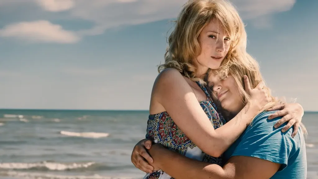 Iveta Bartošová, ztvárněná Annou Fialovou, objímá svého syna Artura na pláži ve třetí sérii seriálu "Iveta".