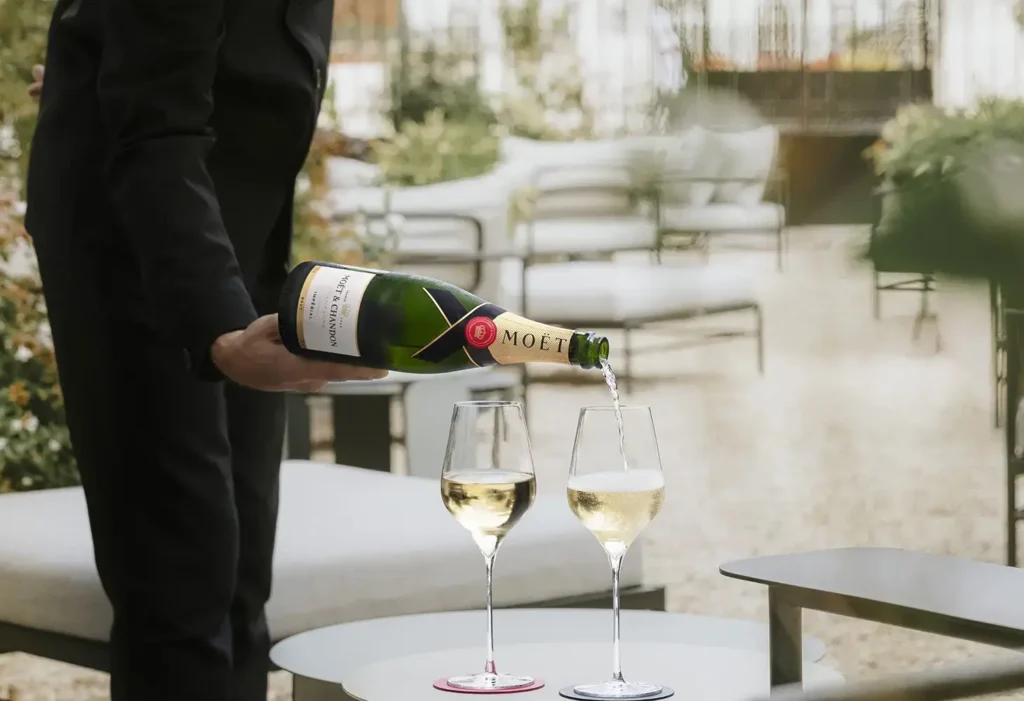 Moet-Chandon_3-2 | Venclíkovi.cz Číšník nalévá šampaňské Moët & Chandon do dvou sklenic na terase.
