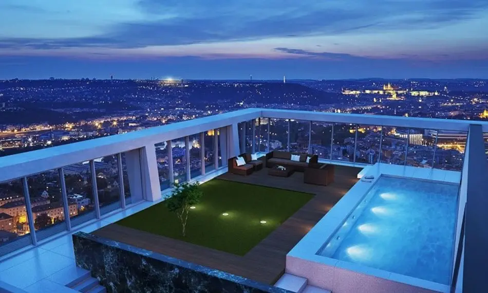 Luxusní střešní terasa s bazénem a výhledem na večerní Prahu, moderní nábytek a panoramatická okna s výhledem na Pražský hrad a centrum města.
