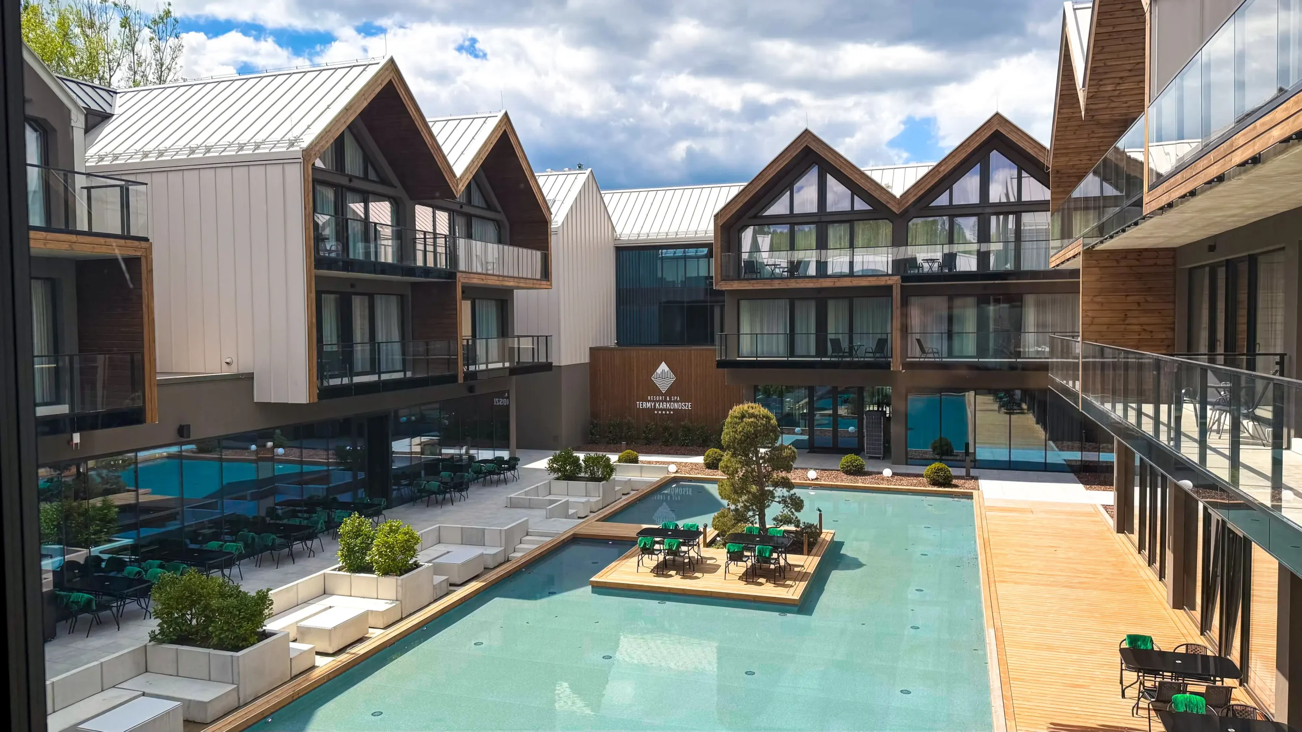 Designový vnitroblok hotelu Termy Karkonosze Resort & Spa s terasami, relax zónou a vodní plochou, ideální pro wellness pobyt na podzim.