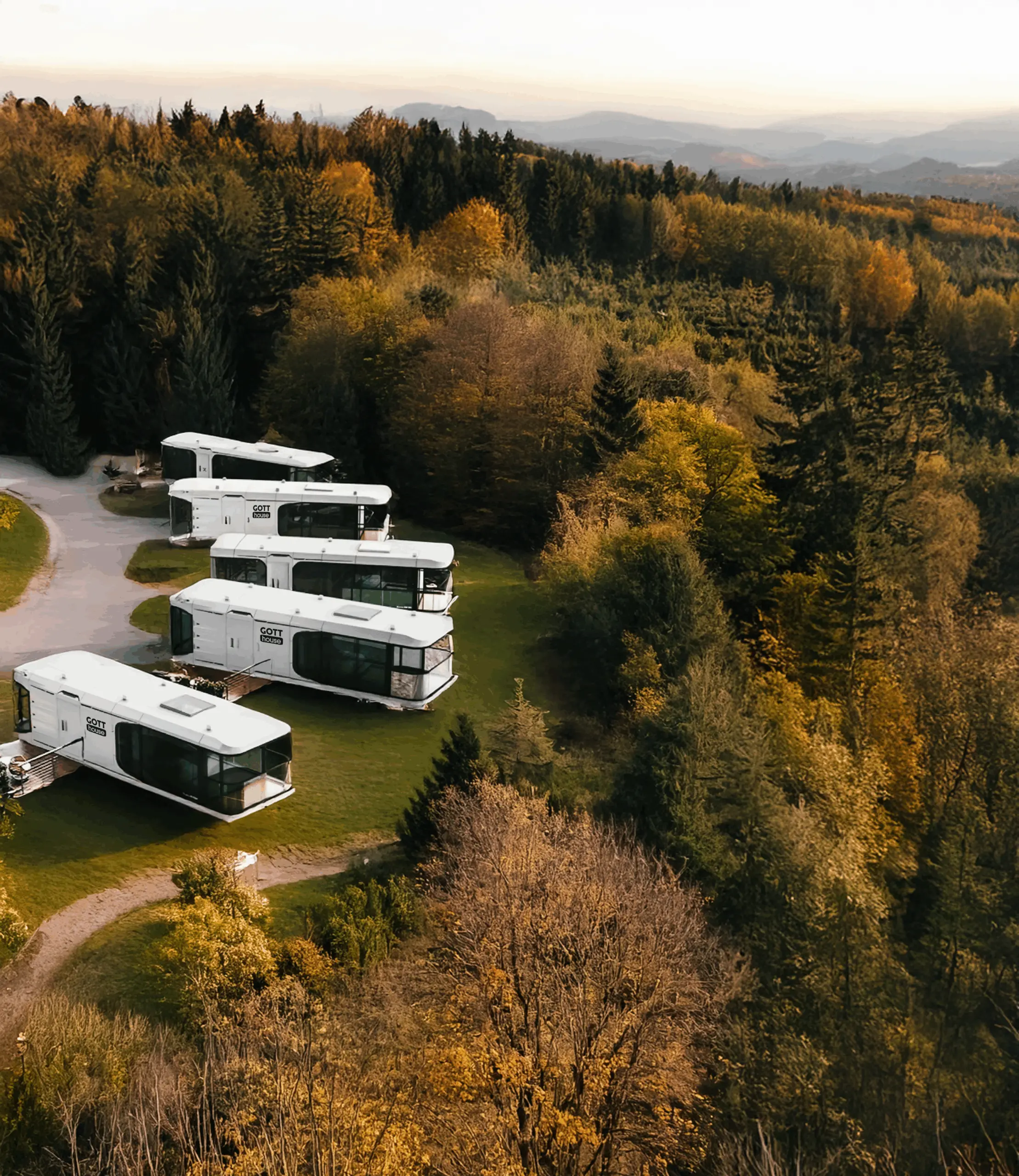 Skupina moderních mobilních domů GOTThouse v lese během podzimu, ideální pro glamping nebo resort