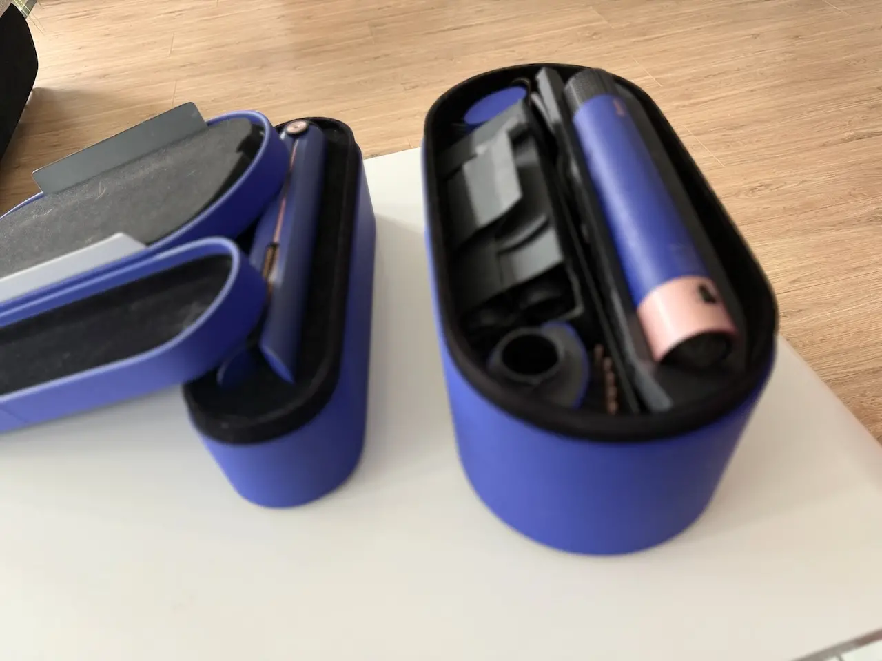 Otevřená pouzdra s Dyson Airwrap Long a žehličkou Corrale, připravené na používání