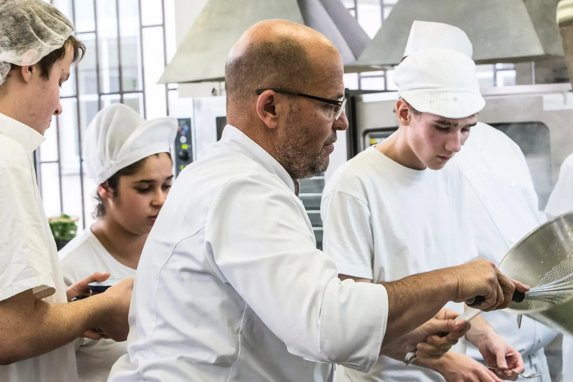 Ano šéfe TV pořad-2 | Venclíkovi.cz Zdeněk Pohlreich v kuchyni při práci s mladými kuchaři – typická scéna z Ano, šéfe!, kde jde nejen o vaření, ale hlavně o lekce života a upřímnou kritiku.