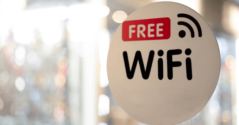 Nápis „Free WiFi“ na vstupních dveřích kavárny nebo letiště, označující bezplatné veřejné připojení k internetu.