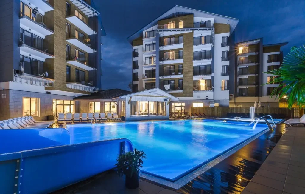 Večerní atmosféra u osvětleného venkovního bazénu v luxusním hotelu v polských Krkonoších, ideální místo pro noční relax
