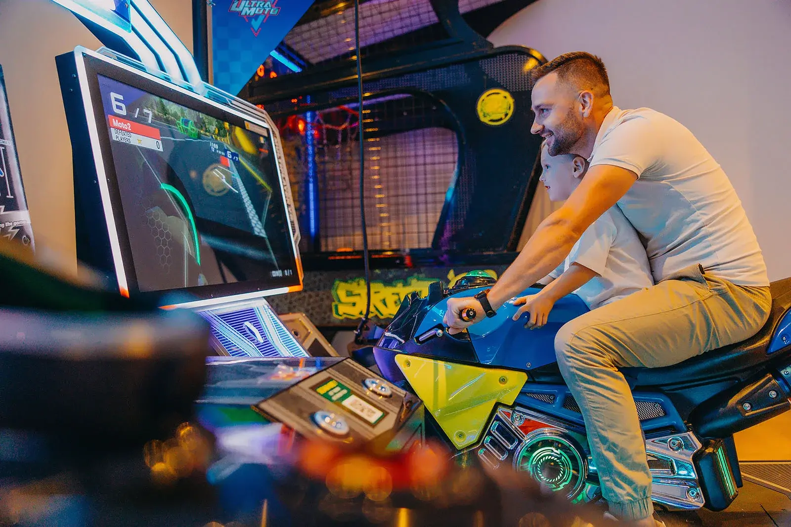 Táta se synem u závodního simulátoru v herně Osady Śnieżka – skvělá zábava pro děti i dospělé, když venku prší nebo je chvilka volna