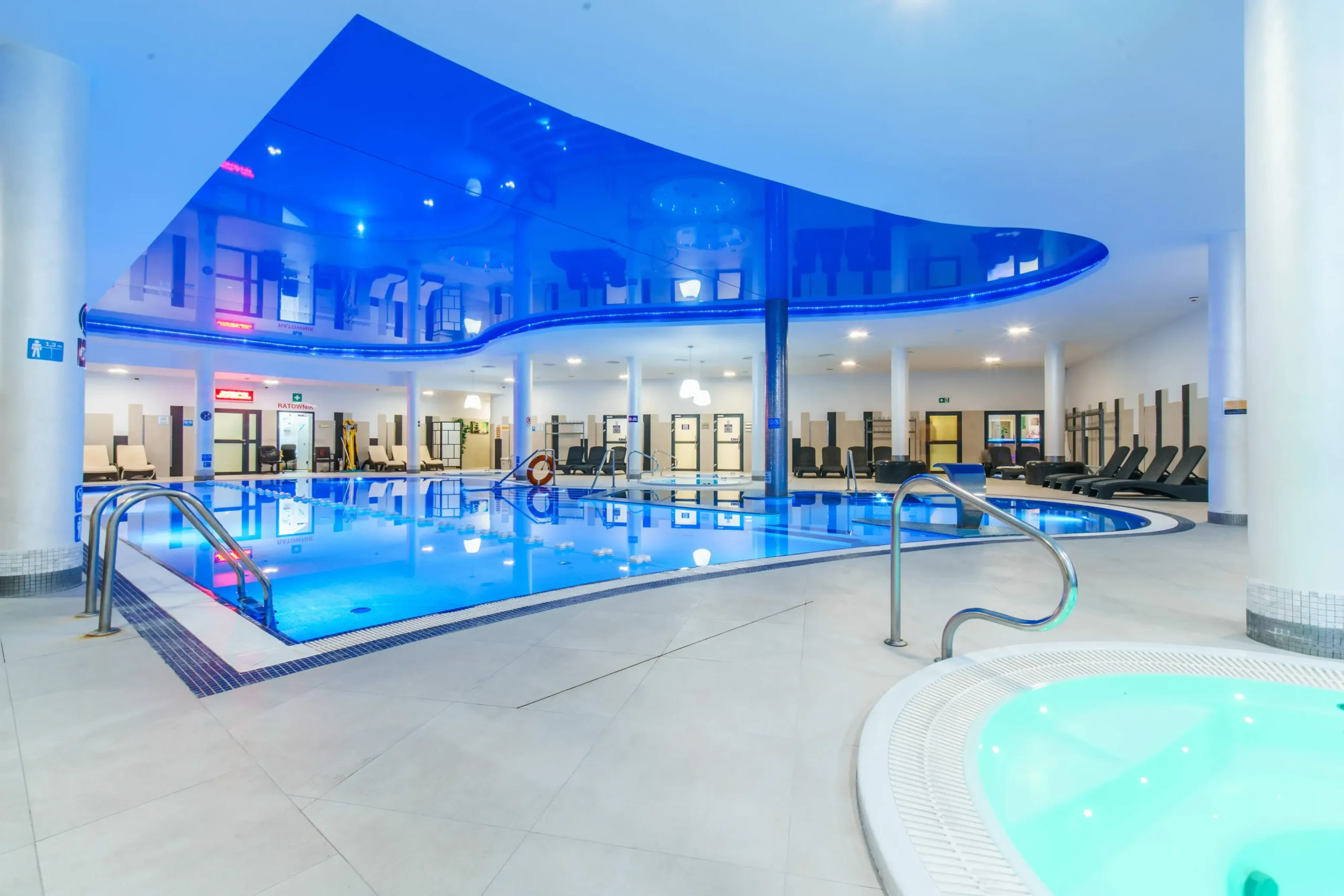 Moderní wellness centrum v Osadě Śnieżka – velký vnitřní bazén, vířivka a relax zóna s lehátky, ideální na odpočinek po výletě nebo večer, když děti usnou.