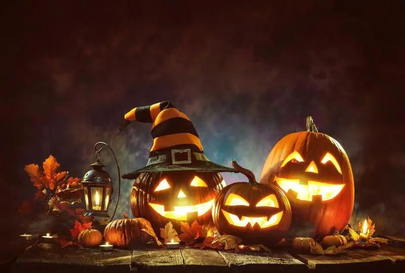 rozsvícené halloweenské dýně s čarodějnickým kloboukem a svíčkami