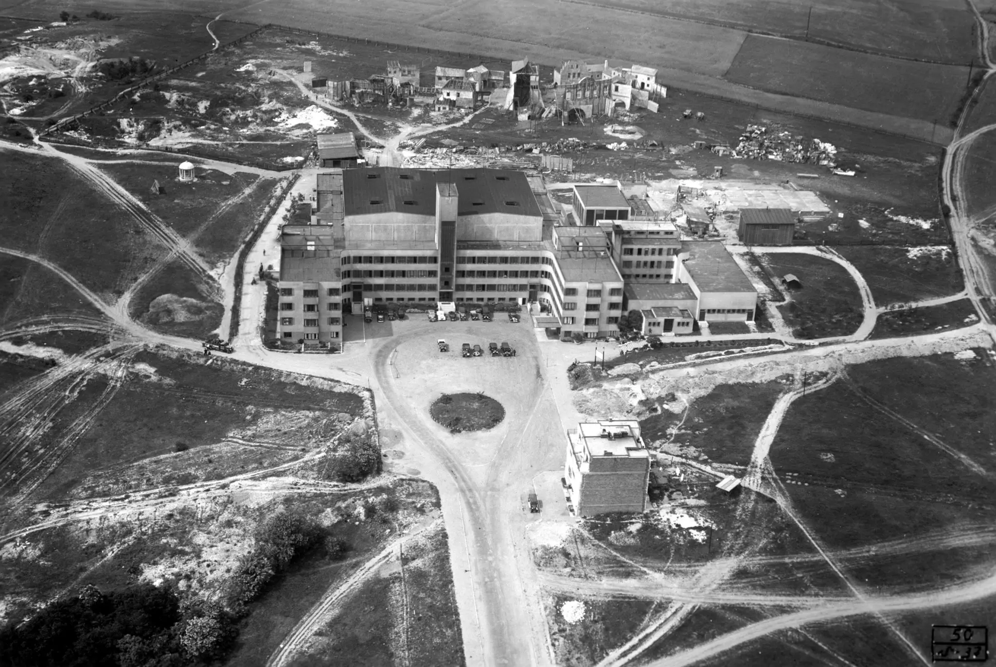 Letecký záběr na areál Barrandova z 30. let, obklopený poli a rozestavěnými kulisami.