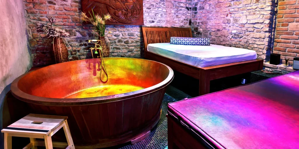 Originální pivní nebo vinná lázeň v dřevěné vaně se světly v rustikálním prostředí