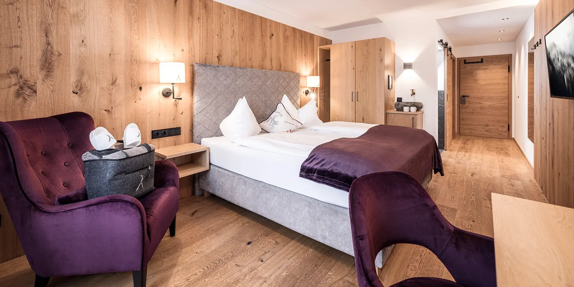 Pokoj v Boutiquehotel Die Alpbacherin | Venclíkovi.cz Moderní pokoj v Boutiquehotel Die Alpbacherin s dubovým interiérem, box spring postelí a křeslem pro odpočinek