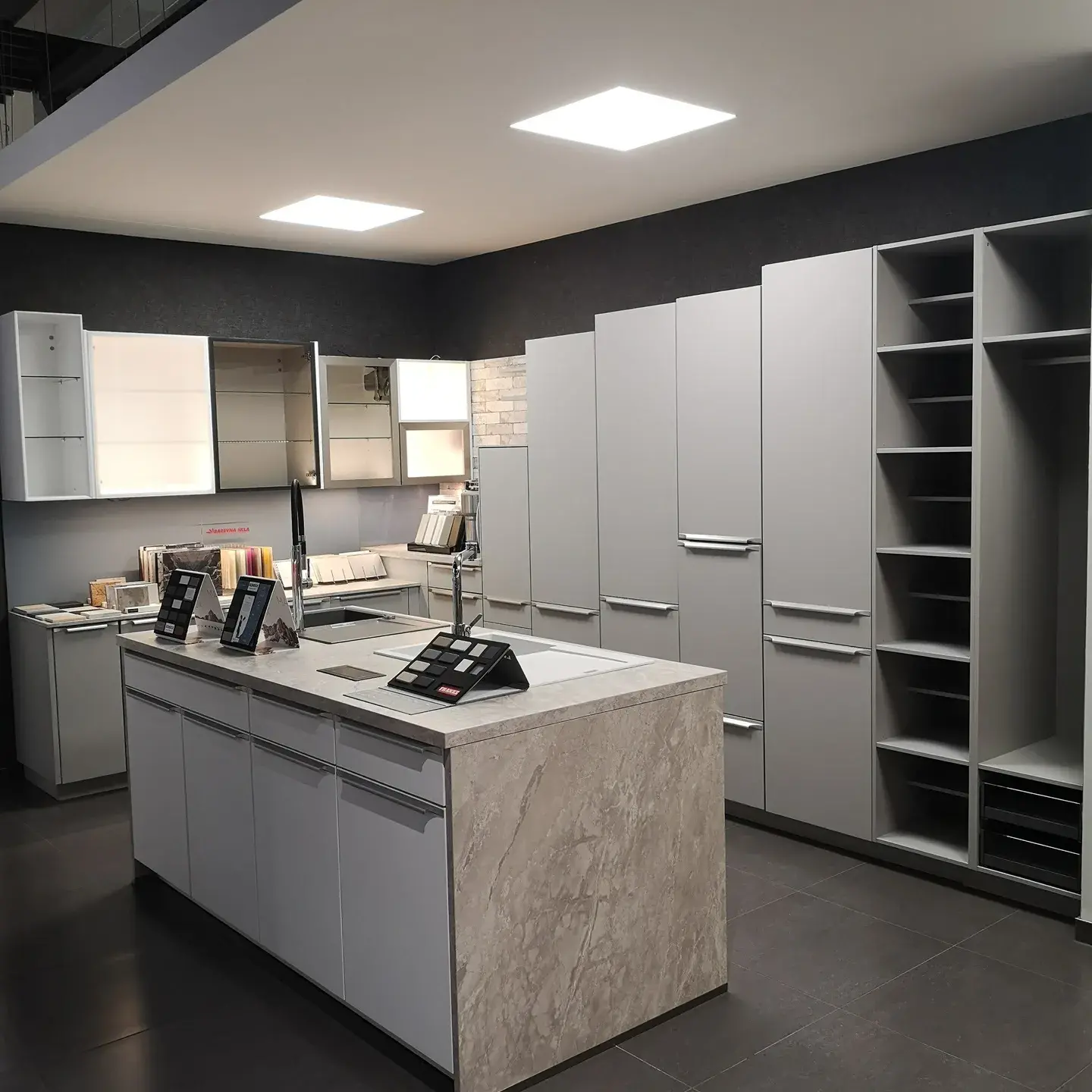 Technická kuchyňská sestava s ostrůvkem a vysokými úložnými skříněmi v šedém provedení