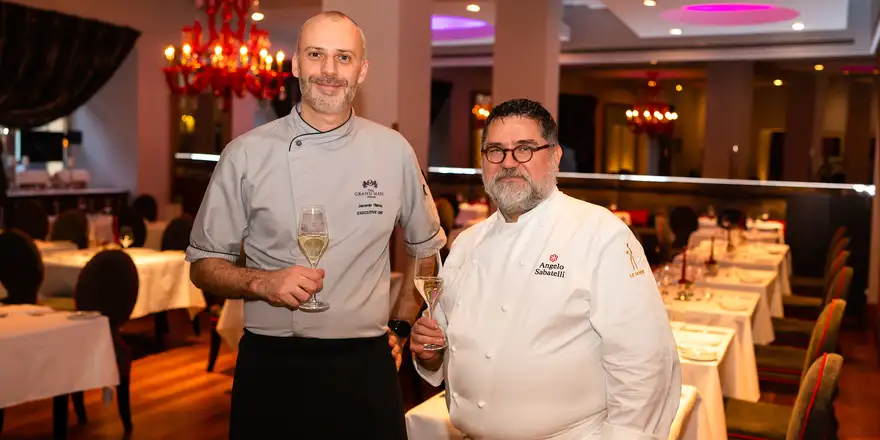 michelinky | Venclíkovi.cz Dva šéfkuchaři v restauraci hotelu The Grand Mark Prague držící sklenky vína