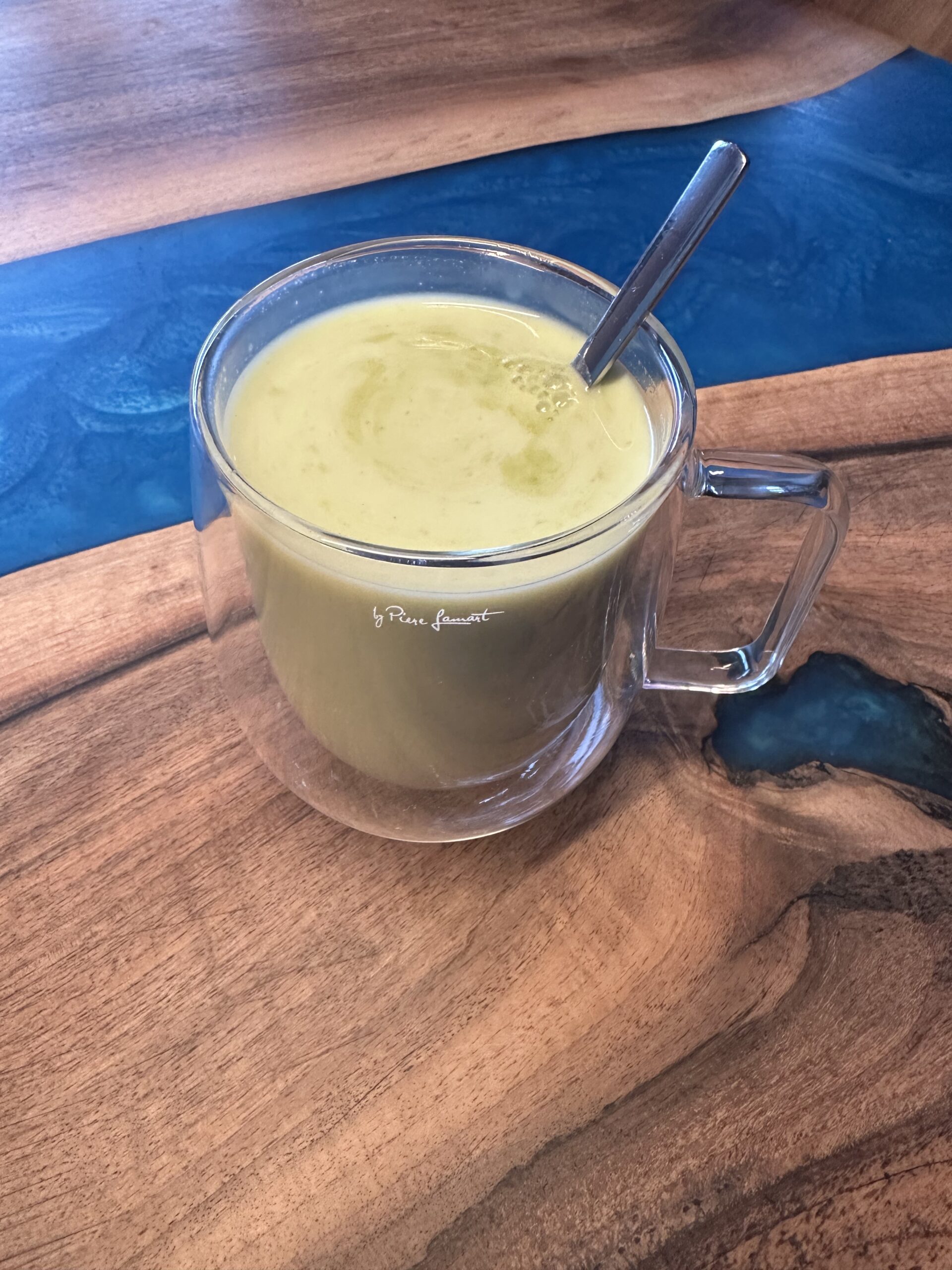 IMG_8958 | Venclíkovi.cz Detailní pohled na krémové vanilkové matcha latté v čirém hrníčku s kovovou lžičkou.