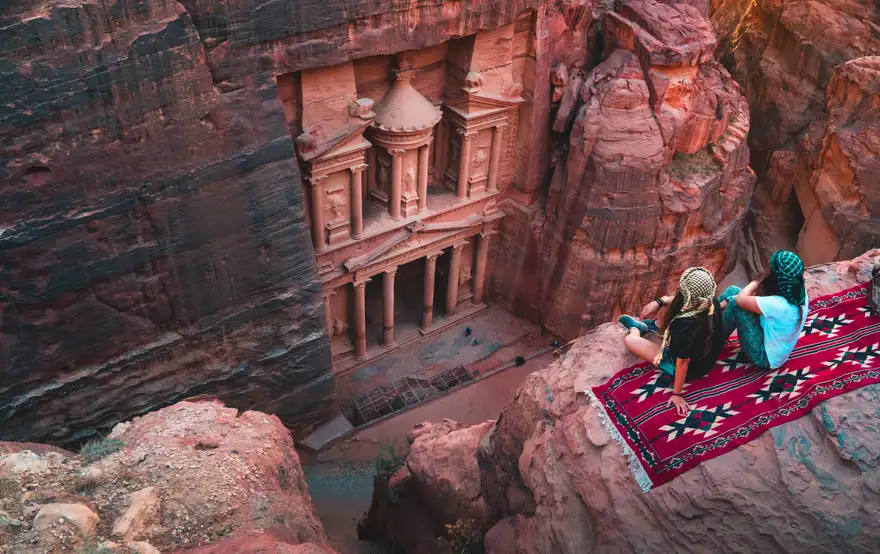 Petra skalni mesto | Venclíkovi.cz Výhled na Pokladnici v Petře z vyhlídky s dvěma sedícími lidmi na koberci