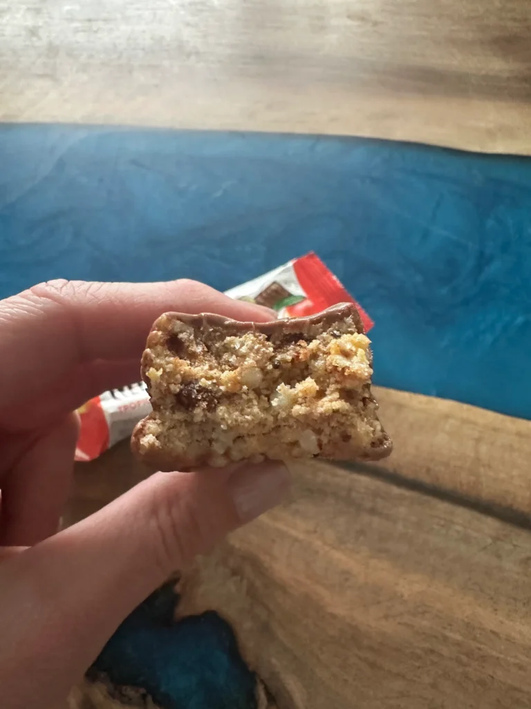 IMG_9090 | Venclíkovi.cz Detail řezu proteinové tyčinky Mealbar Tropical Fruit s viditelnou hutnou strukturou