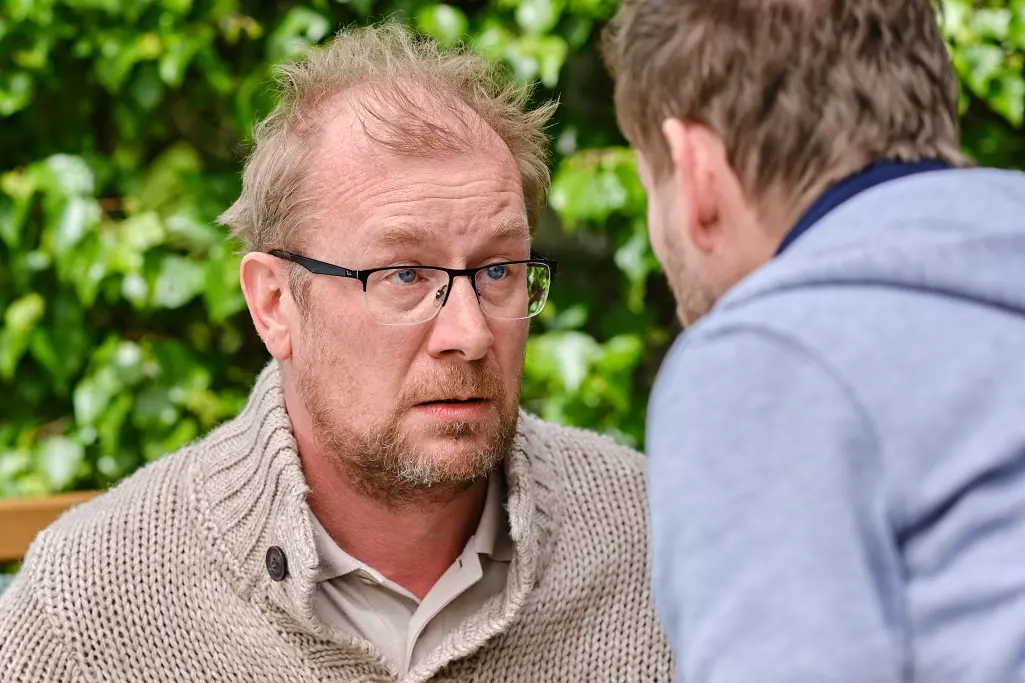 Neco-za-neco_Martin-Pechlat-a-Mira-Nosek-foto-Vojtech-Resler-Drive-Film-Factory_Bratrijpg | Venclíkovi.cz Detailní pohled na muže, který pozorně naslouchá vážnému rozhovoru, jeho výraz je soustředěný, klidný a rozhodný, jako by už věděl, co je potřeba udělat.