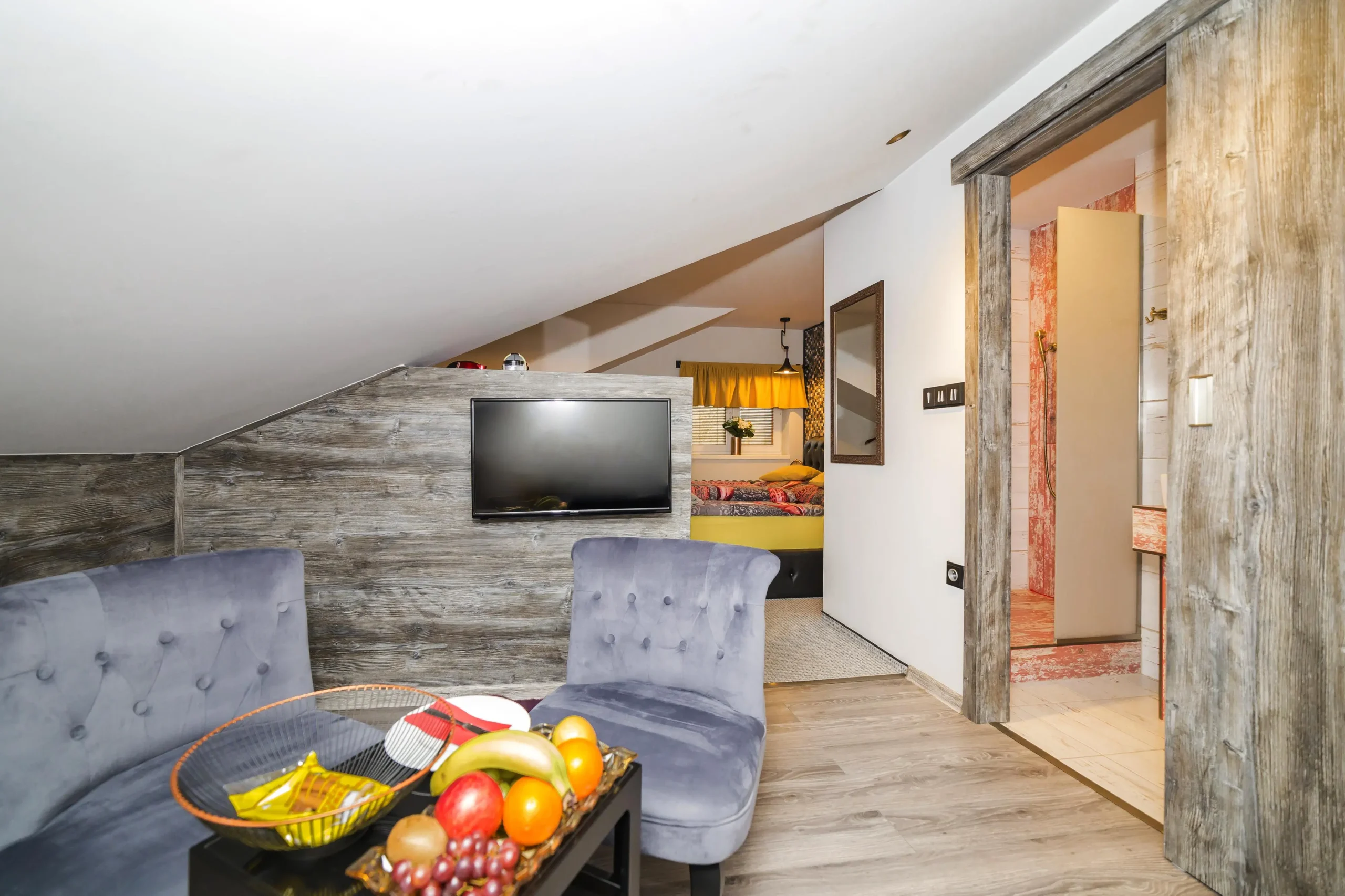 Padre Ostrava 2 | Venclíkovi.cz Stylový interiér pokoje v Padre Boutique Hotelu s designovými křesly, dřevěným dekorem a výhledem do ložnice.