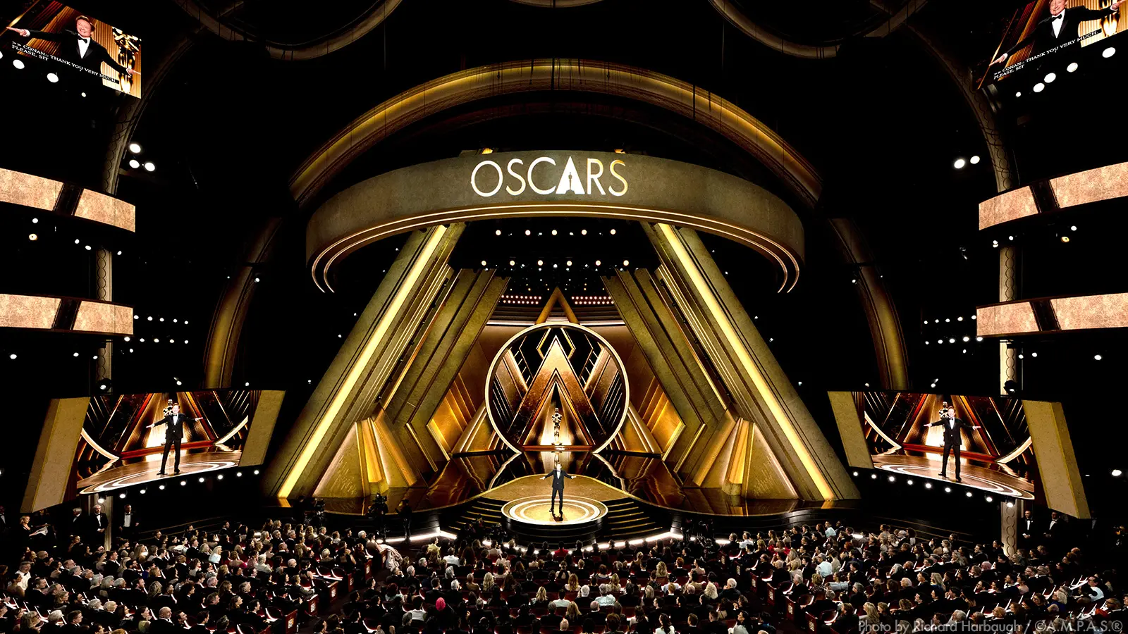 Udílení akademie Oscars 2026 Hollywood | Venclíkovi.cz Interiér Dolby Theatre v Hollywoodu během udílení Oscarů 2026, velkolepě nasvícené pódium se zlatými kulisami ve tvaru písmene A a nápisem OSCARS nad scénou plnou diváků.