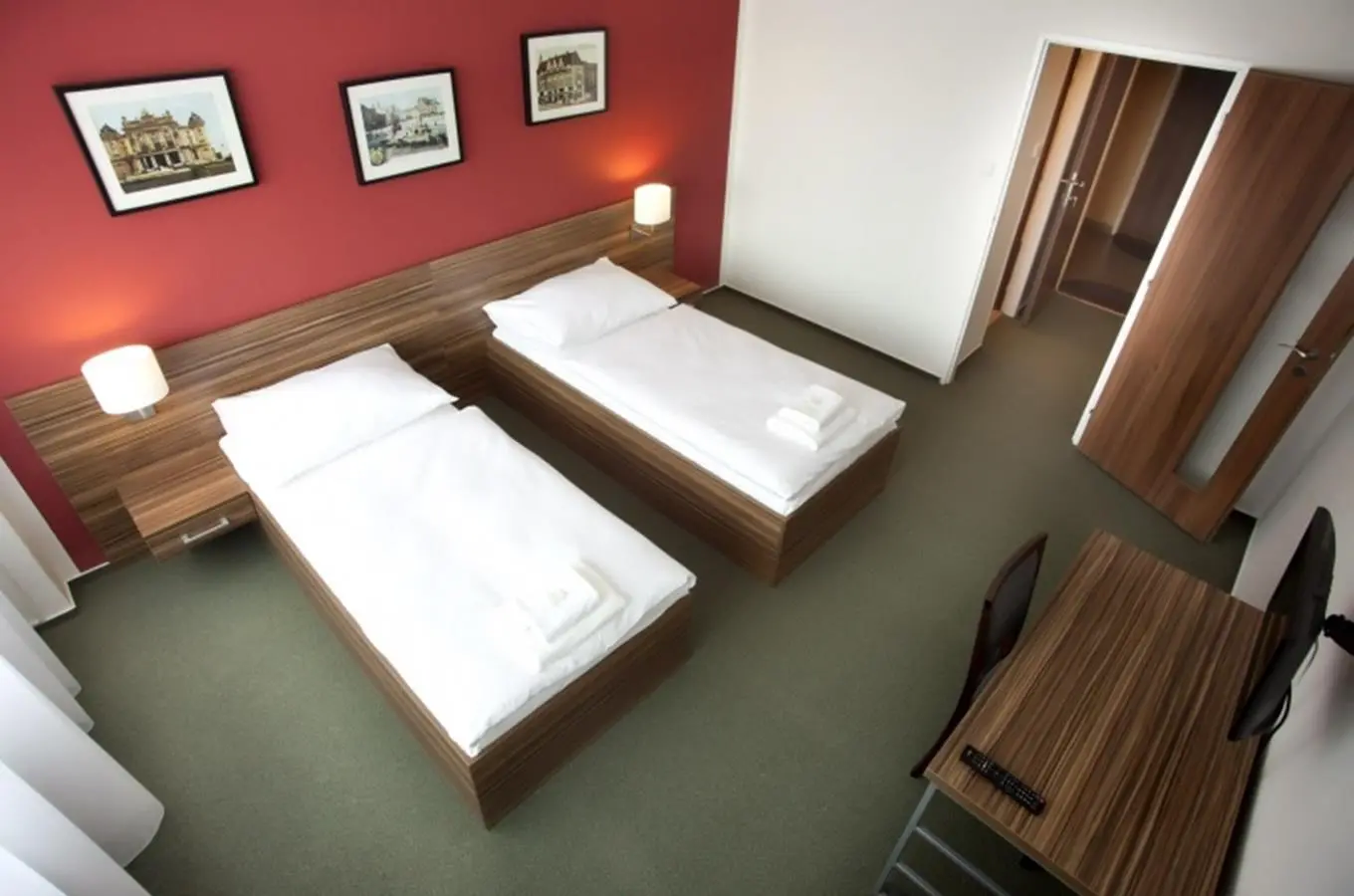 hotel veronika 4 | Venclíkovi.cz Pohled na hotelový pokoj se dvěma oddělenými postelemi, červenou stěnou a dřevěným nábytkem v Hotelu Veronika.