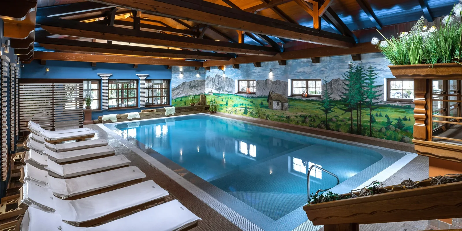 Vnitřní bazén hotelu Alpejski Boutique v Karpaczi s dřevěnými trámy a lehátky