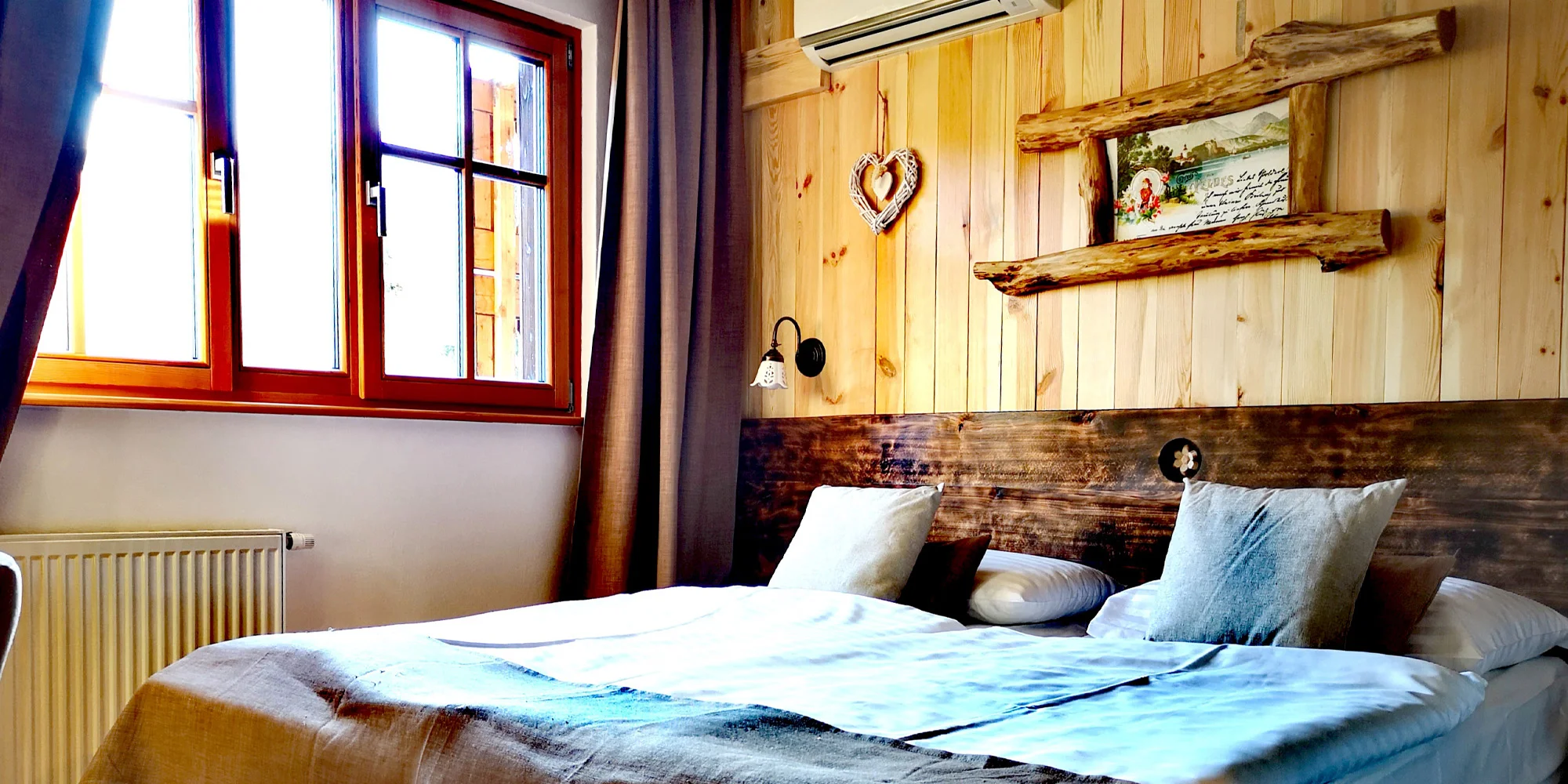 Dvoulůžkový pokoj hotelu Ribno s dřevěným obložením a velkým oknem