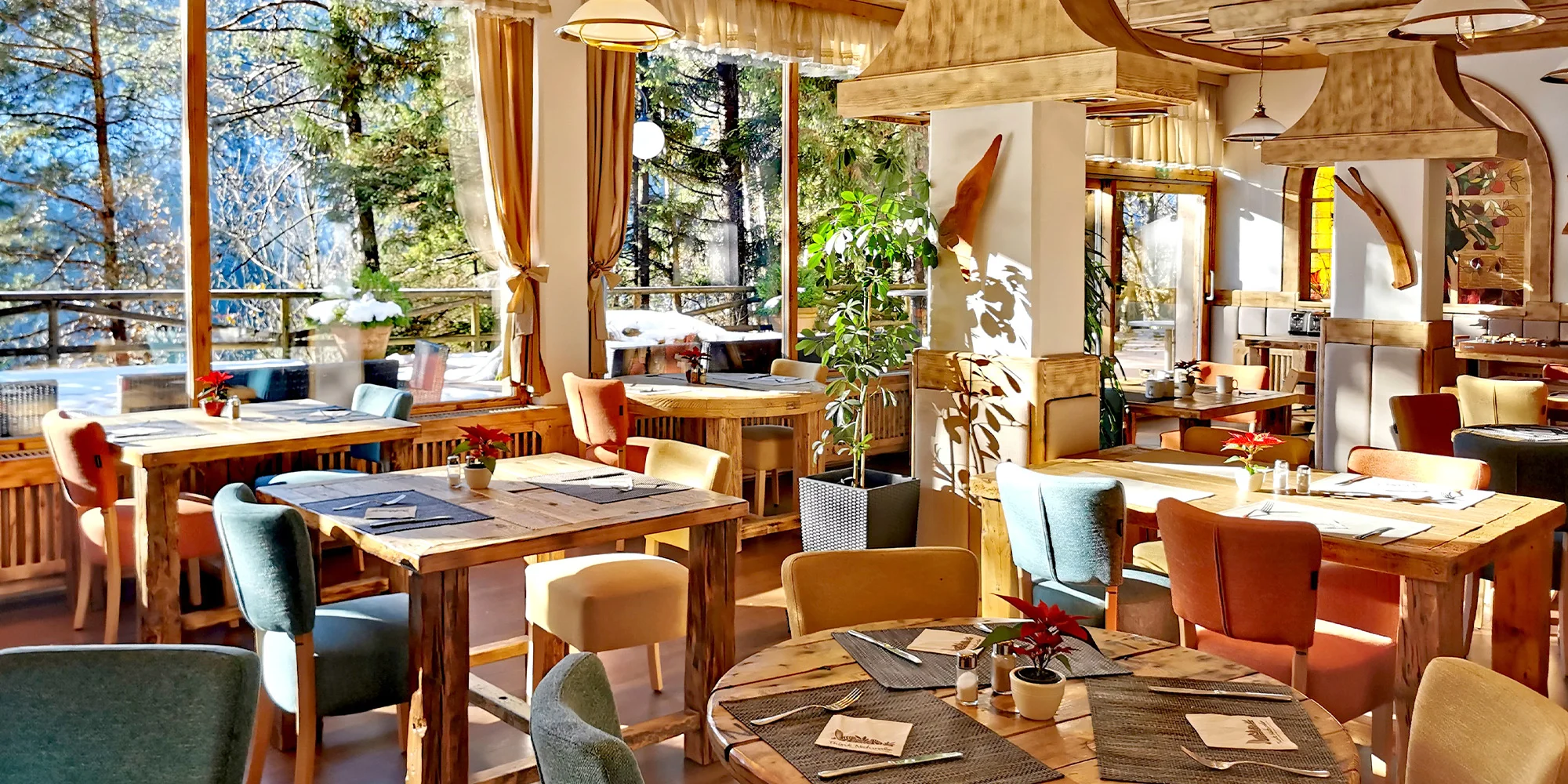 Restaurace hotelu Ribno s dřevěnými stoly a okny do lesa