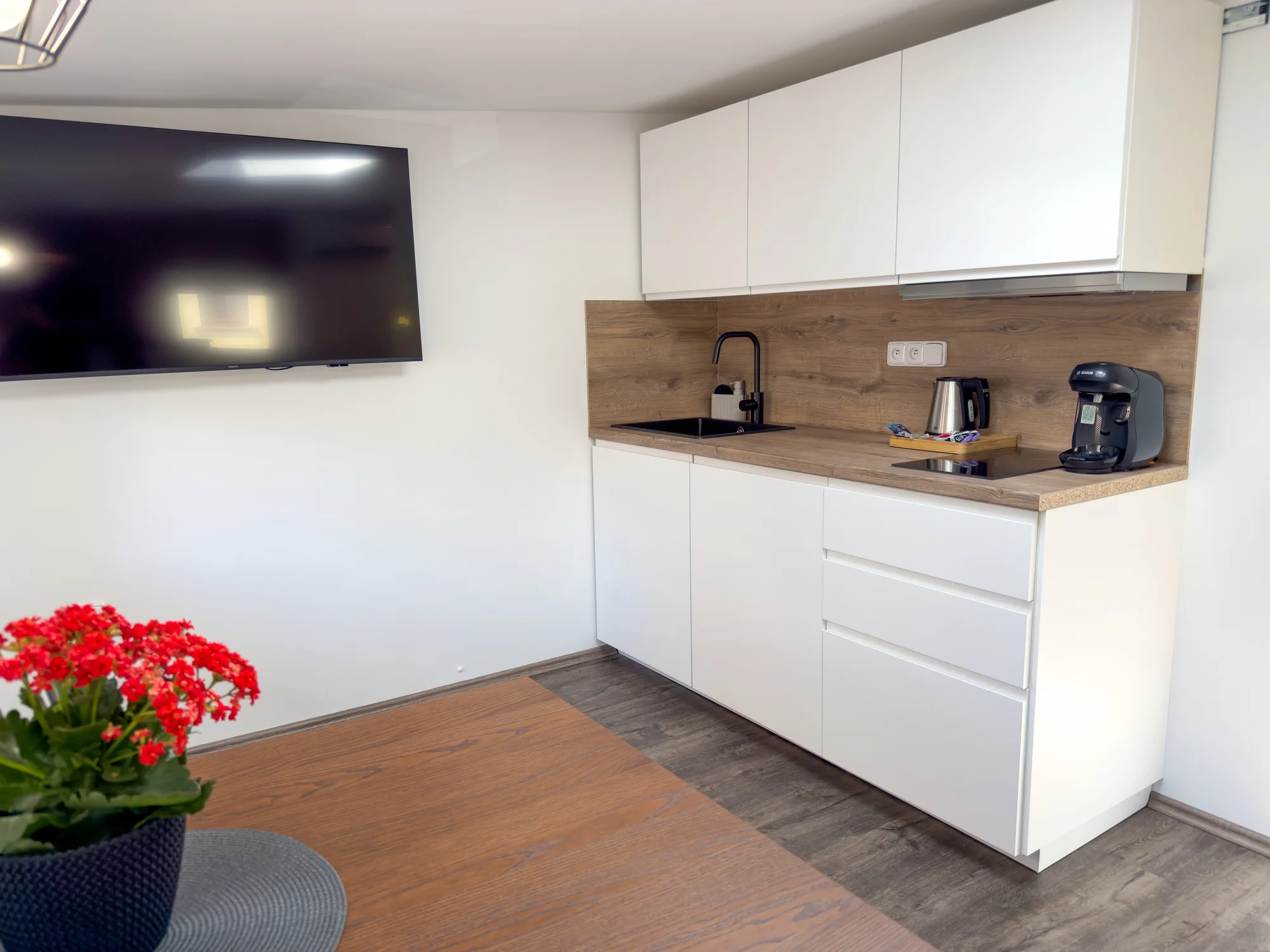 Bílá kuchyňská linka s dřezem a kávovarem v Apartmánech za divadlem