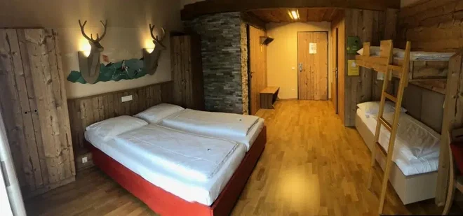 Dřevem obložený rodinný pokoj s palandou v JUFA Hotel Annaberg