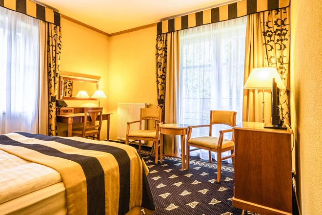 Ukázka pokoje hotelu Richard se stolem u okna