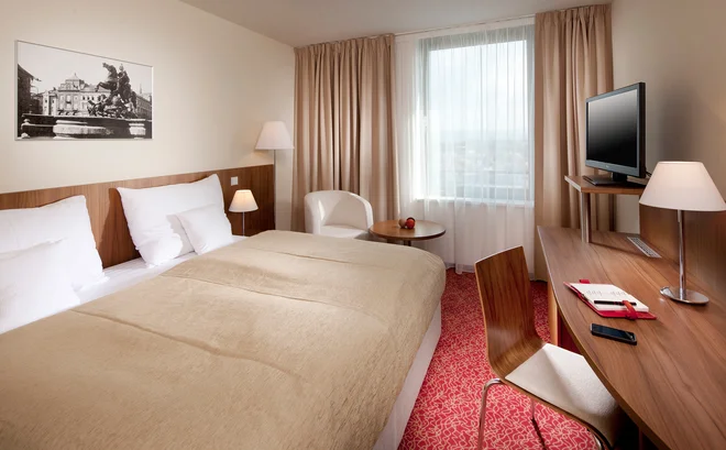 Světlý dvoulůžkový pokoj Clarion Congress Hotelu Olomouc s psacím stolem a křeslem u okna