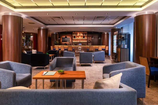 Lobby Clarion Congress Hotelu Olomouc s šedými křesly a barem v pozadí