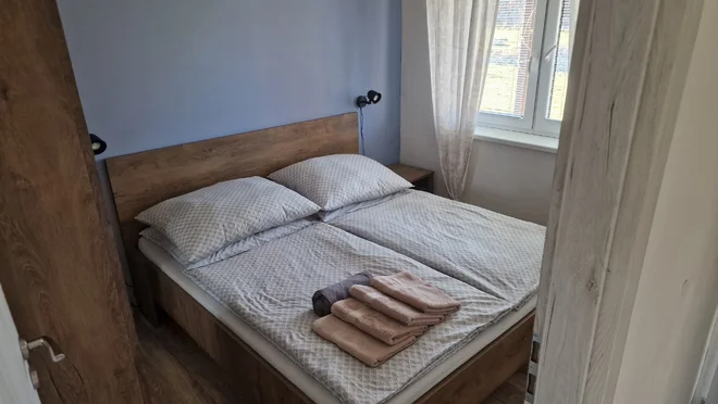 Samostatná ložnice apartmánu Pod Bukovkou s dvojlůžkem a ručníky