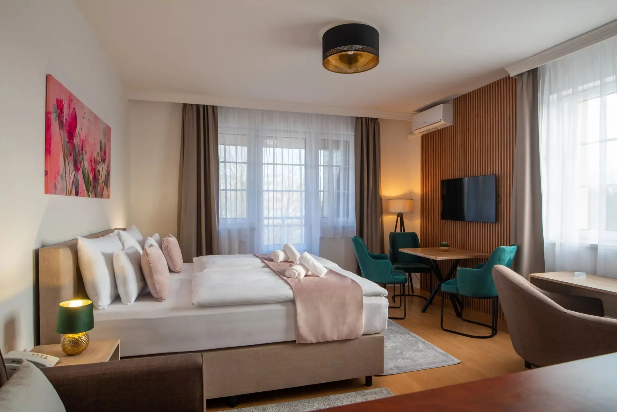 Ložnice apartmánu v Holdvirág Hotelu v Sárváru s manželskou postelí a posezením
