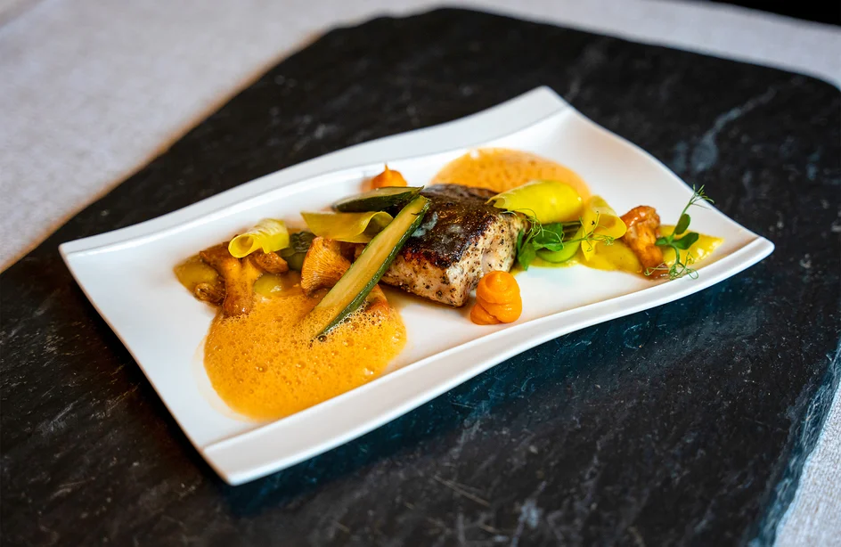 Gurmánský chod z restaurace hotelu Pulverer s čerstvou rybou a sezónní zeleninou