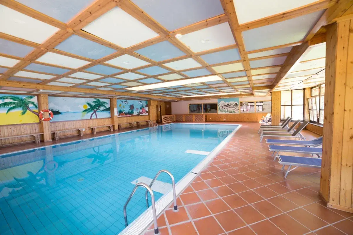 Vnitřní bazén hotelu Sancamillo s výhledem ven a teplou vodou po lyžování