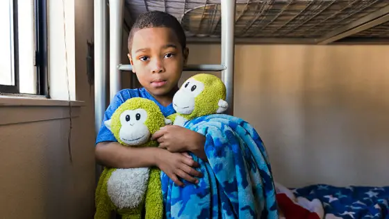 oblibeny plysak | Venclíkovi.cz Malý chlapec sedí na posteli a drží plyšovou hračku, která mu pomáhá zvládnout odchod do školky.